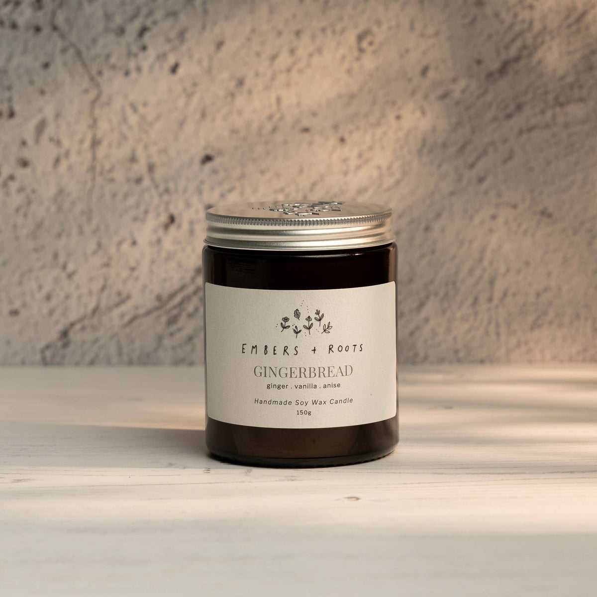 Embers & Roots Gingerbread Christmas soy candle in an amber glass jar with silver lid