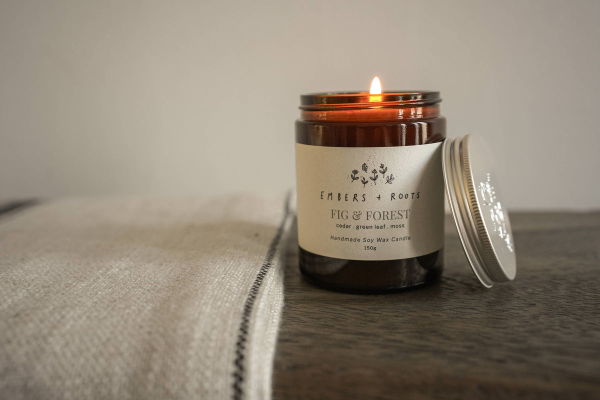 Embers & Roots soy candle styled on a wooden surface