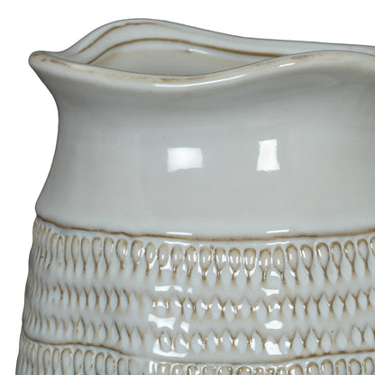 Close-up of a ceramic pitcher with textured design on a white background