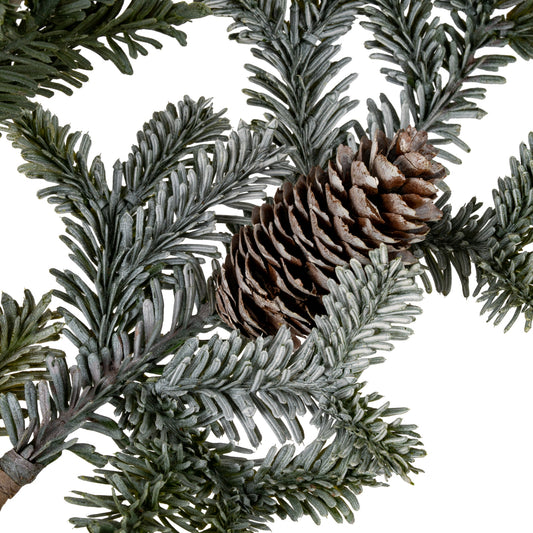 Close-up of pine branches with a pine cone on a white background