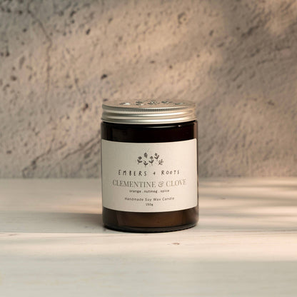 Embers & Roots Clementine & Clove Christmas soy candle in an amber glass jar