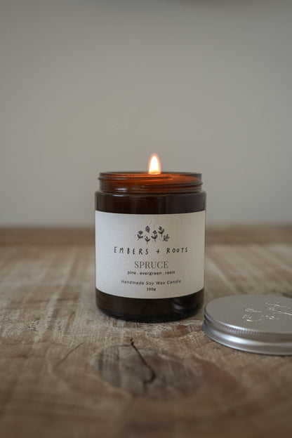 Lit Embers & Roots soy candle photographed in a home setting